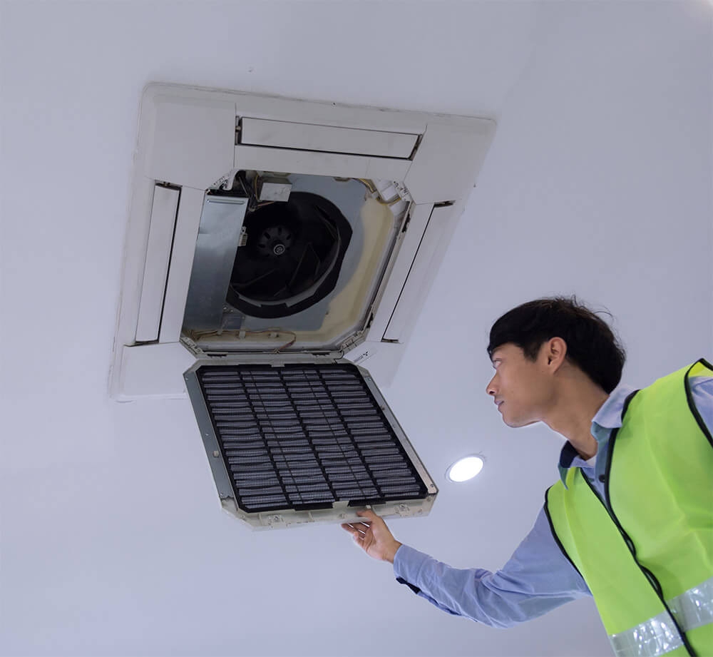 Engineer servicing a ceiling cassette air conditioning unit